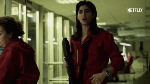 Woman In Red Jumpsuit Holding Gun GIF