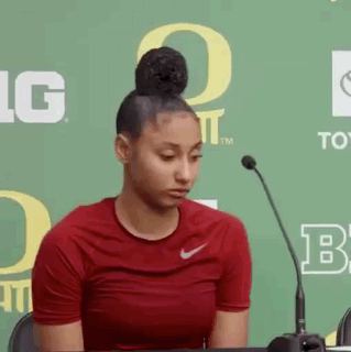 Woman in Red Nike Shirt Sitting at Microphone