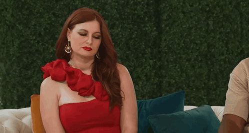 Woman in Red One-Shoulder Dress on Couch