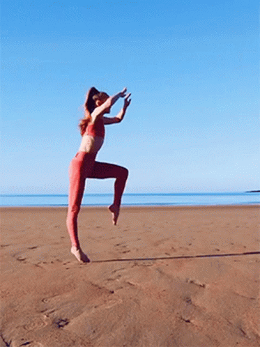 Woman In Red Pants Jumping On Beach GIF