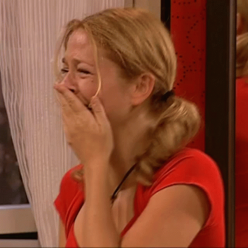 Woman in Red Shirt Covering Face With Hands