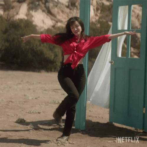 Woman in Red Shirt Dancing in Front of Netflix Door