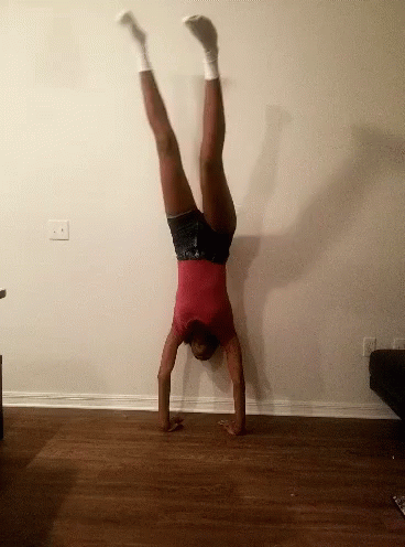 Woman in Red Shirt Doing Handstand