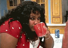 Woman In Red Shirt Drinking From Cup GIF