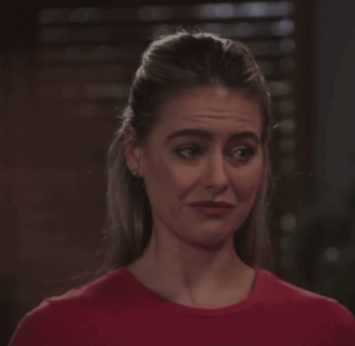 Woman In Red Shirt Looking At Camera GIF