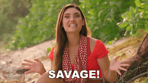 Woman In Red Shirt Sitting On Beach With Hands Outstretched Saying Savage GIF