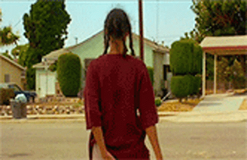 Woman in Red Shirt Walking Past House