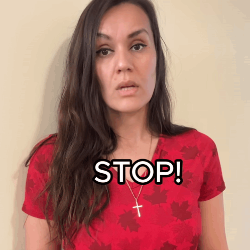 Woman in Red Shirt with Maple Leaves and Cross Necklace Says Stop