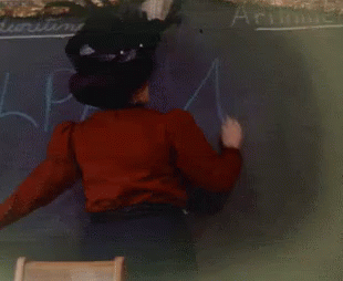 Woman In Red Shirt Writing Arithmetic On Blackboard GIF