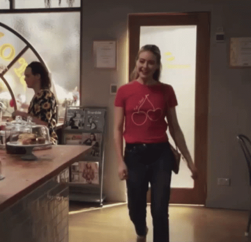 Woman in Red T-Shirt With Cherries Walking Through Restaurant