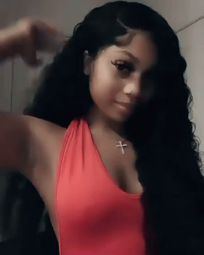Woman in Red Tank Top and Cross Necklace Taking Selfie