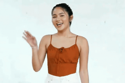 Woman In Red Tank Top Smiling And Waving GIF