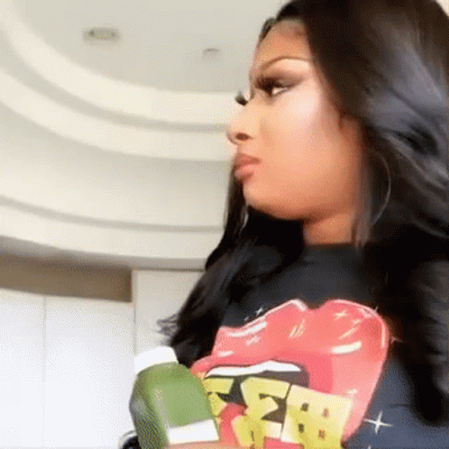 Woman in Rolling Stones T-Shirt Holding Green Object