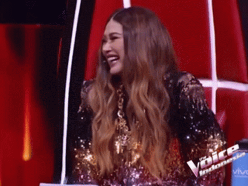 Woman in Sequined Dress Laughing on Red Chair