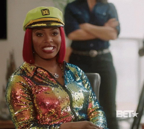 Woman in Sequined Jacket and Captain Hat Smiling