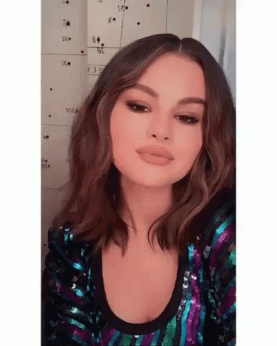 Woman In Sequined Top Taking Selfie GIF