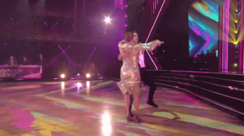 Woman in Silver Dress Dancing With Man