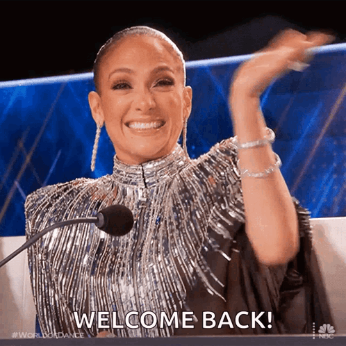 Woman in Silver Dress Saying Welcome Back
