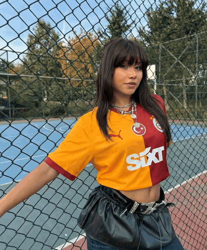 Woman in Sixt Shirt by Fence