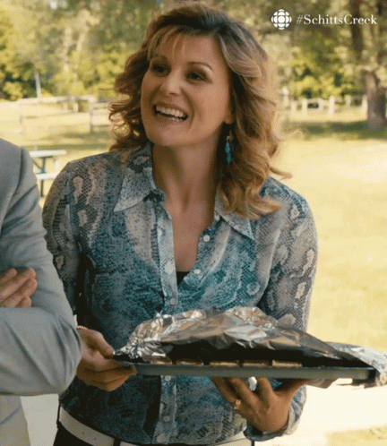 Woman in Snake Print Shirt Smiling with Food