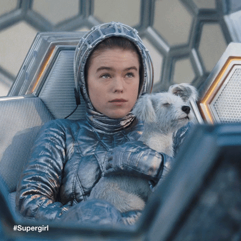 Woman In Space Suit Holding Small Dog GIF