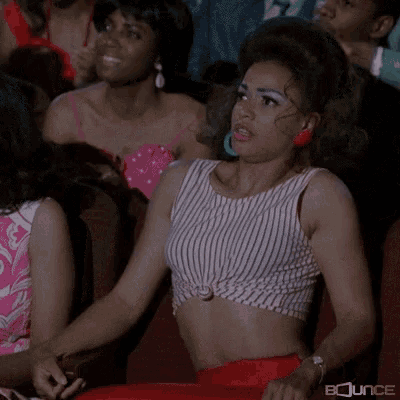 Woman in Striped Crop Top Sitting in Theatre