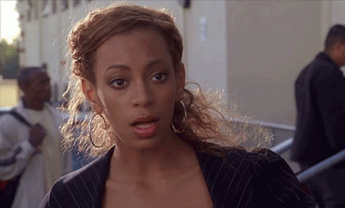 Woman In Striped Jacket And Hoop Earrings In Front Of Building 1212 GIF