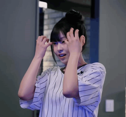 Woman In Striped Shirt Holding Hair GIF