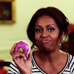 Woman in Striped Shirt Holding Pink Donut