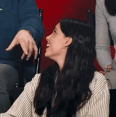 Woman In Striped Shirt Laughing While Man Points GIF