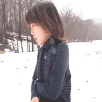 Woman In Striped Sweater Standing In Snow GIF