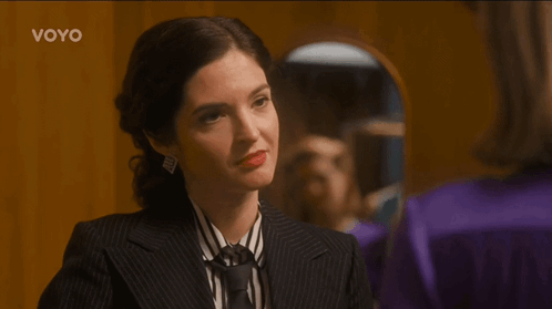 Woman in Suit and Tie Looking in Mirror Voyo