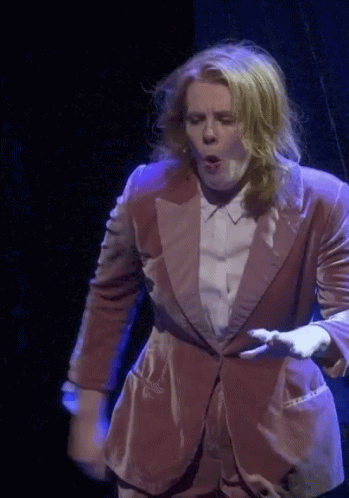 Woman in Suit Dancing on Stage