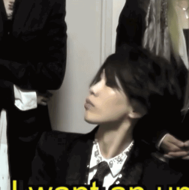 Woman In Suit Sitting In Front Of I Want You Sign GIF