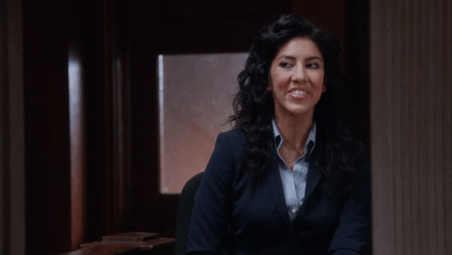 Woman in Suit Smiling in Dark Room