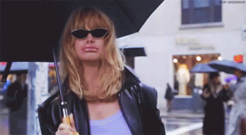 Woman in Sunglasses and Black Jacket Holding Umbrella in Rain