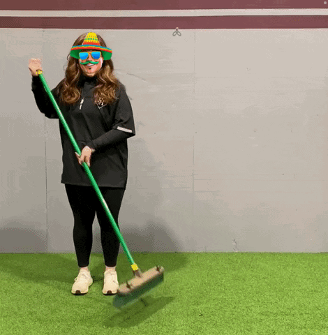 Woman in Sunglasses and Hat Holding Broom