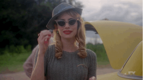 Woman in Sunglasses and Hat Next to Yellow Car