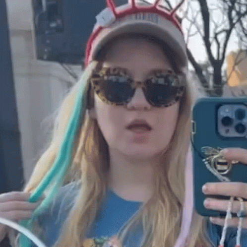 Woman in Sunglasses and Hat Taking Selfie