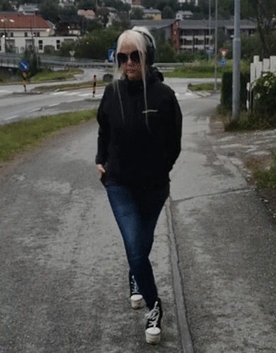 Woman In Sunglasses And Headphones Walking GIF