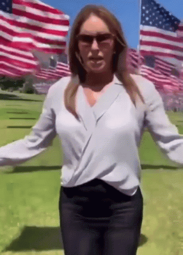 Woman in Sunglasses and White Shirt in American Flag Field