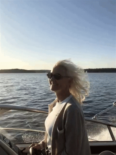 Woman In Sunglasses Driving Boat GIF