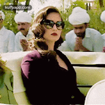 Woman in Sunglasses in Car with Men in Turbans