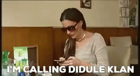 Woman In Sunglasses Looking At Phone Saying I'm Calling Dibule Klan GIF