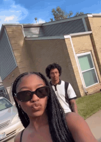 Woman In Sunglasses Next To Man And House GIF