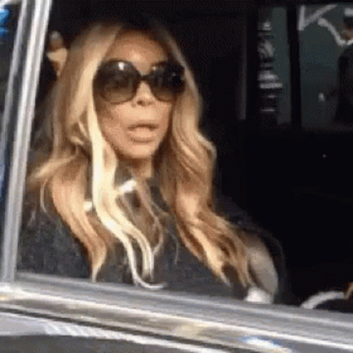 Woman in Sunglasses with Mouth Open in Car