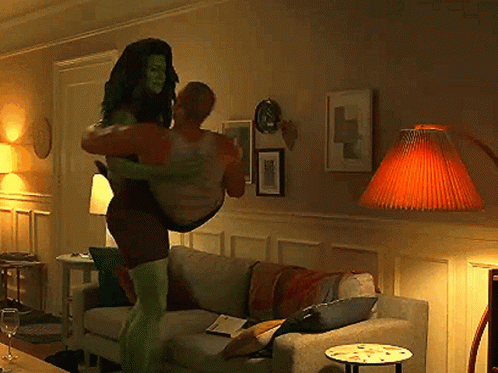 Woman In Superhero Costume Carrying Man GIF