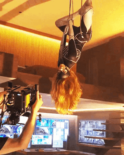 Woman In Superhero Costume Hanging Upside Down GIF