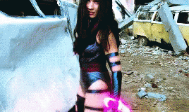 Woman in Superhero Costume in Front of Destroyed Car