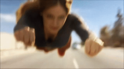 Woman In Superman Costume Flying Over Road GIF